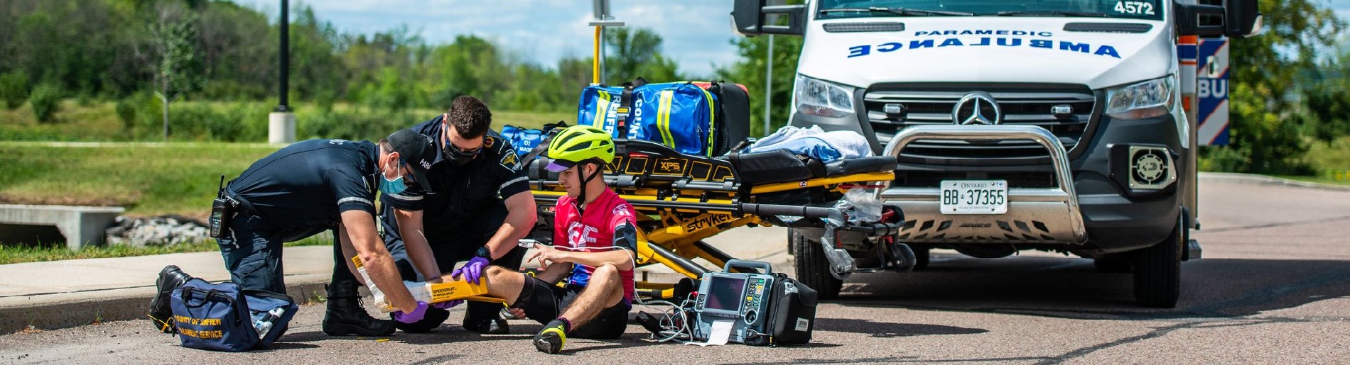 Paramedics with a cyclist on a road