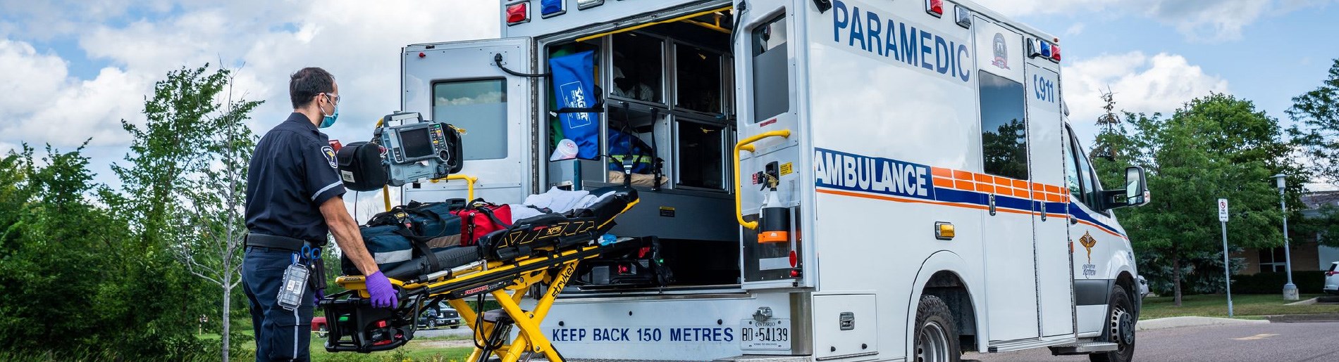Paramedics loading stretcher into an ambulance