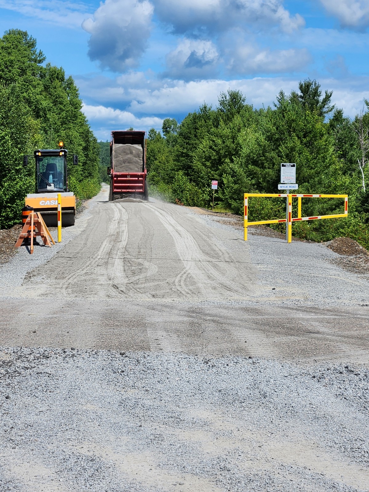 Dump truck in the distance dumping a load of gravel on the Algonquin Trail 