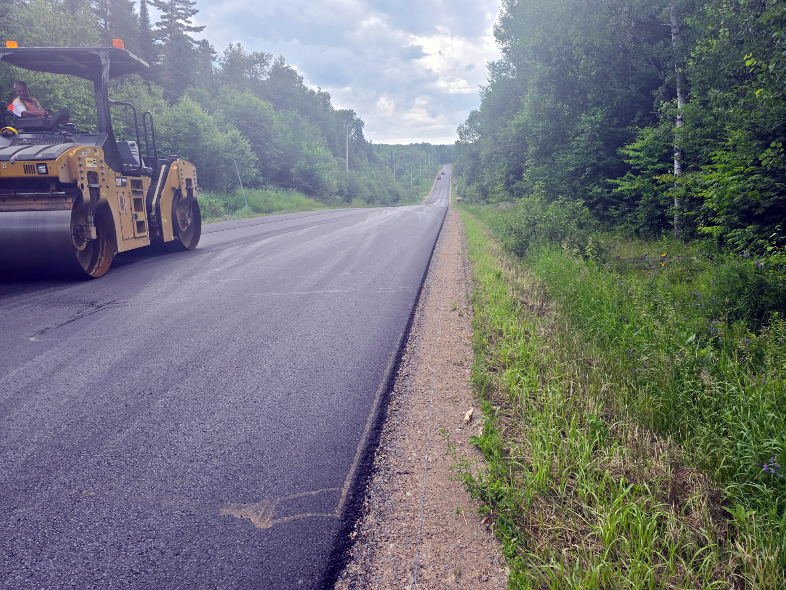 Close up of a paver in action on a construction project, new asphalt