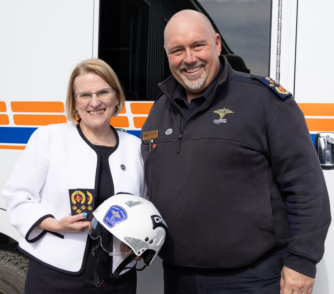 Minister Jones accepting a helmet from Chief Nolan