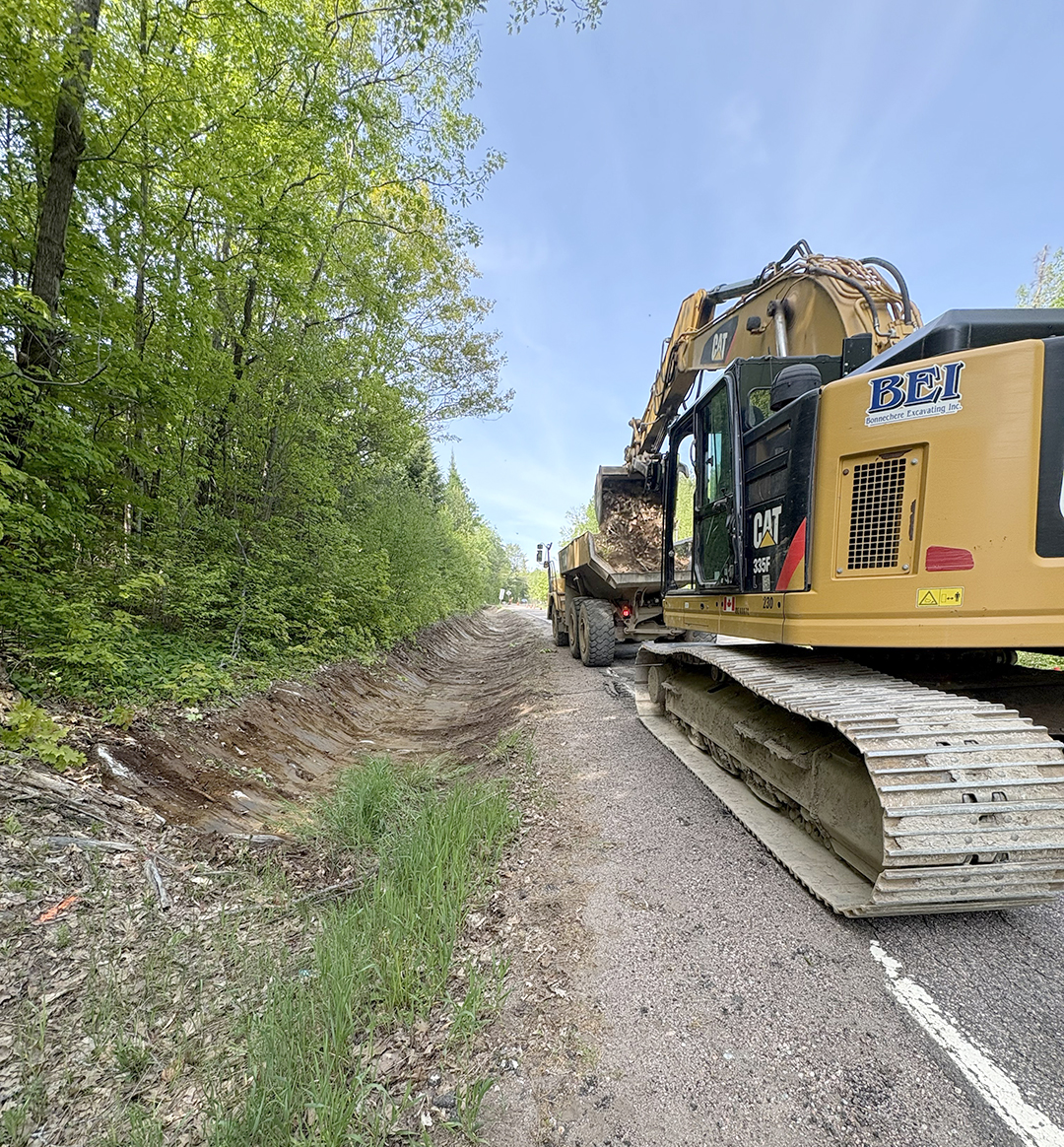 large piece of construction equipment sitting on the side of the road, shot from behind