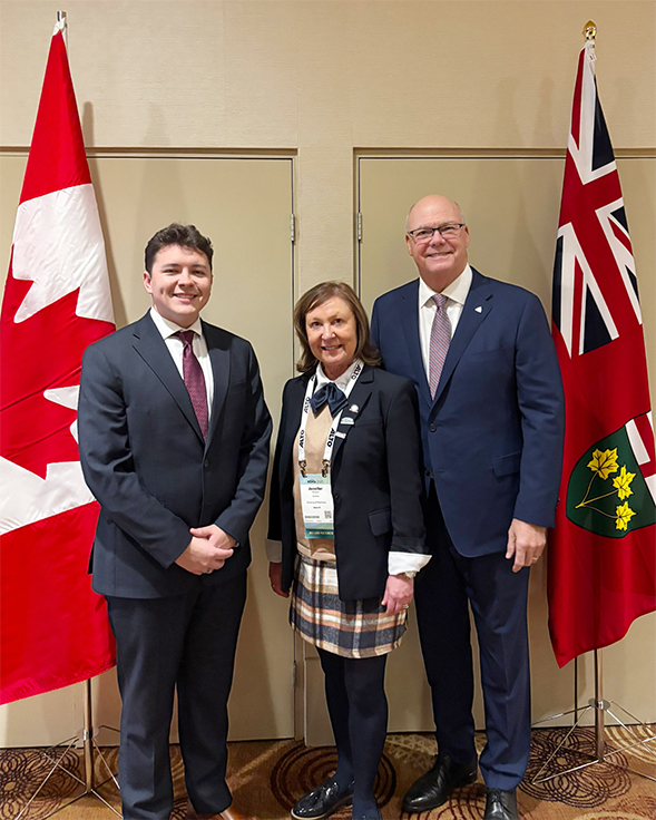 three people standing in front of the Canadian and Ontario flag 