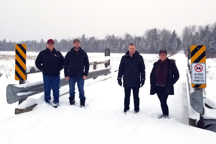 Four people on snowy bridge